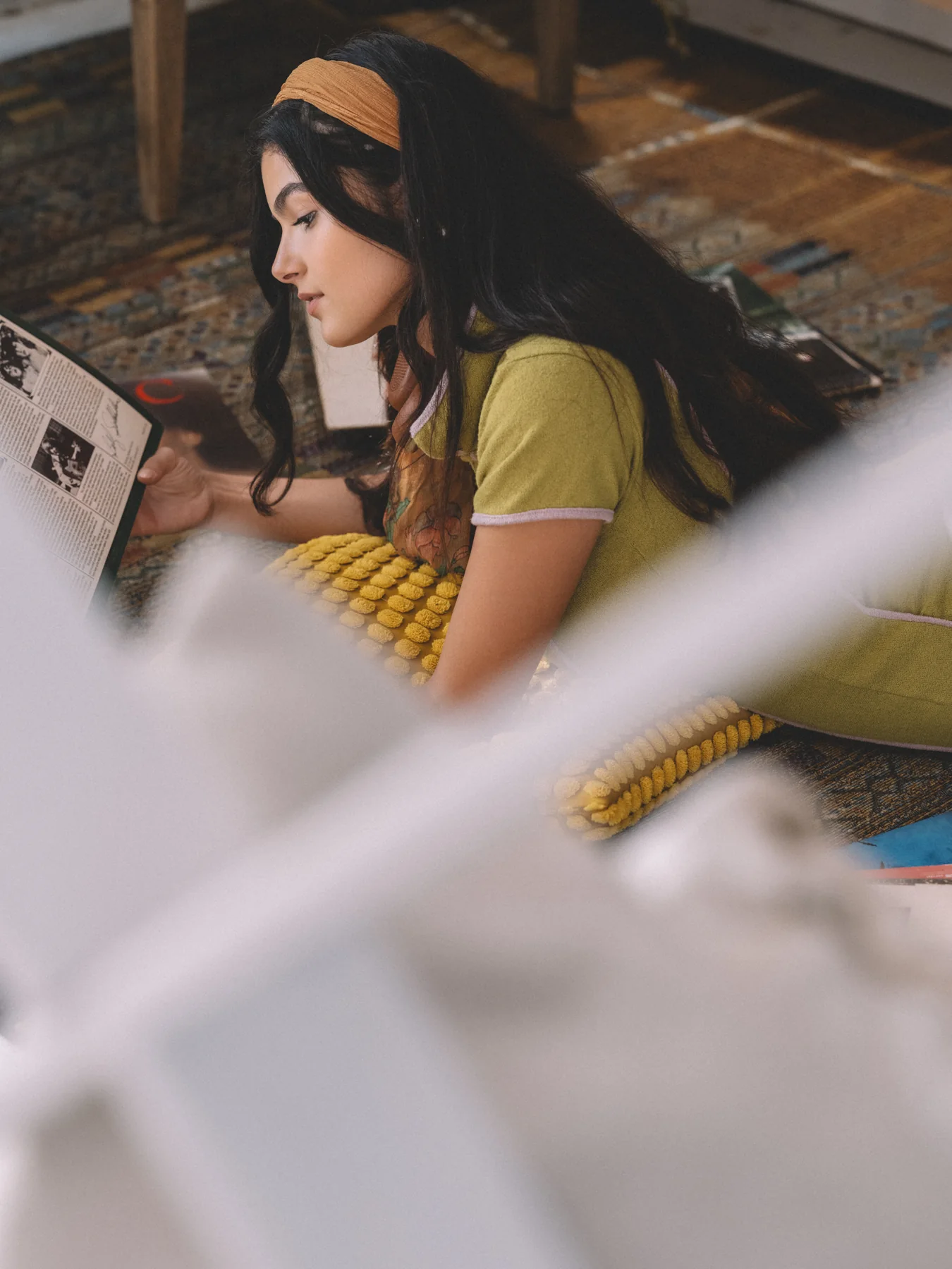 Alexis Santiago looking through a record sleeve beside shelves of vinyl