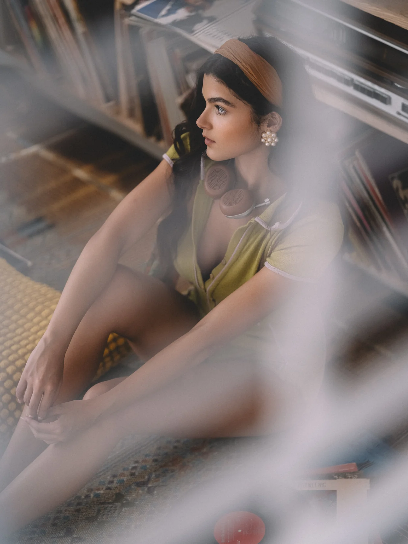 Alexis Santiago seated among records, framed through blurred sleeves in the foreground