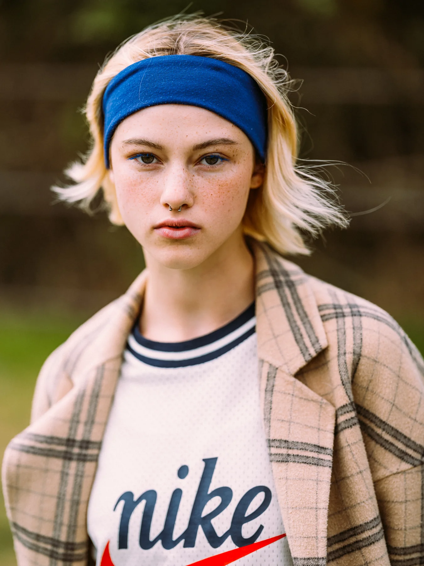 Close-up of Gracie Rae wearing a blue headband and checked jacket outdoors
