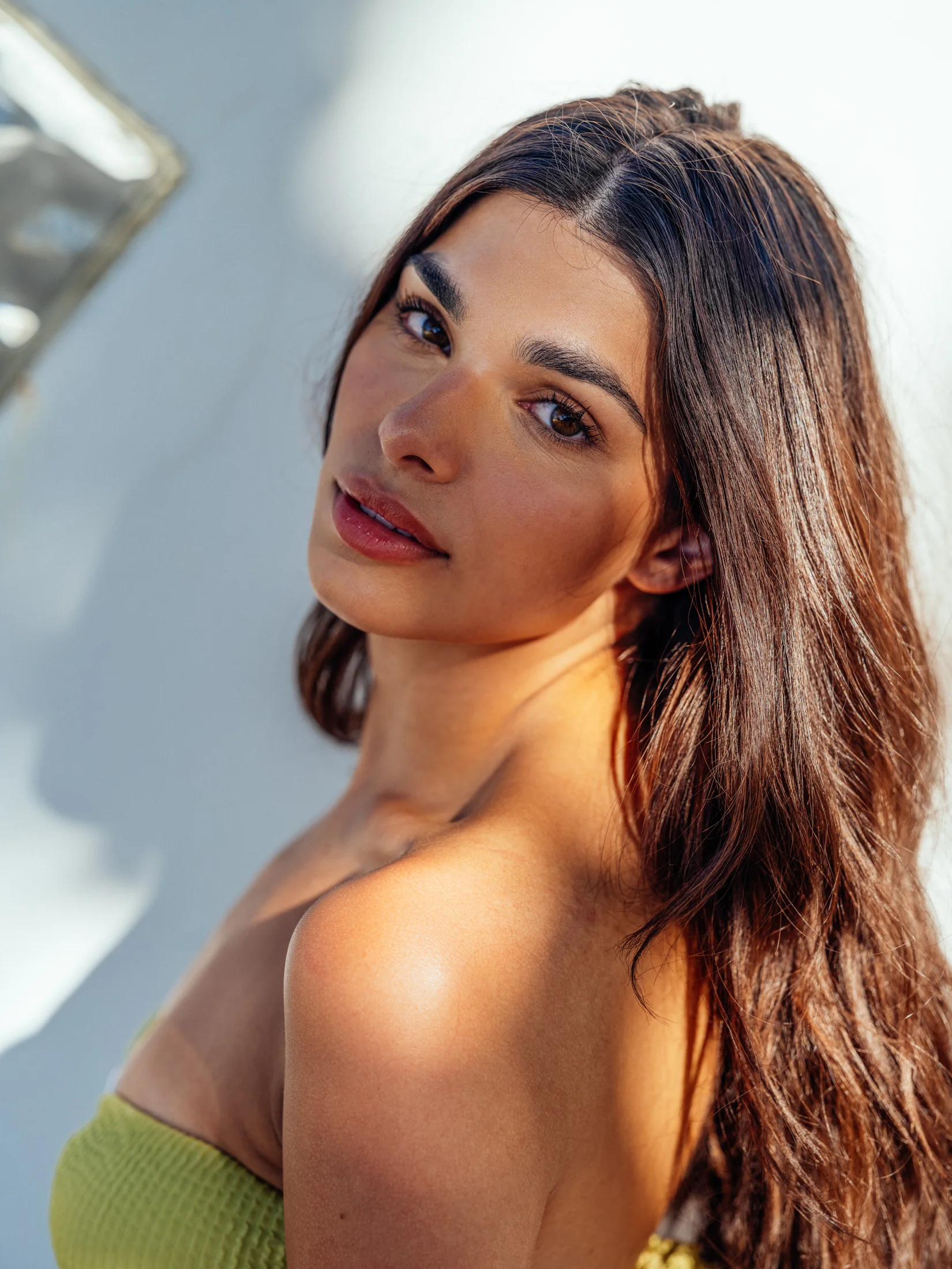 Close-up of Rhea Rai in a green swimsuit with sunlight across her shoulder